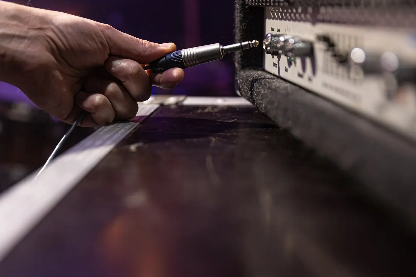 A jack audio connector is being inserted into a socket on an audio device for music/audio.